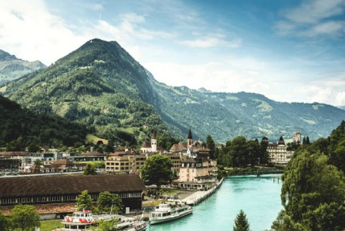 A panoramic view of Interlaken city in Switzerland with river, buildings and mountains in the background