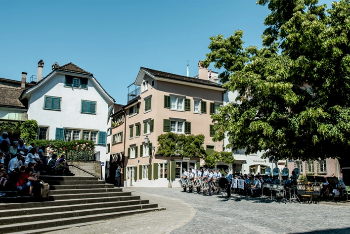 A group of people parading in Old Town located in Zurich, Switzerland