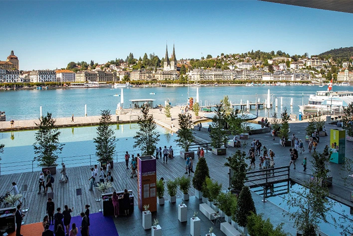 A group of people on a dock next to water celebrating the Lucerne festival