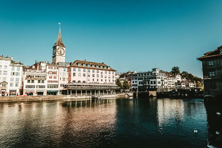 Tranquil view of the Limmat River in Zurich, reflecting the city's historic buildings